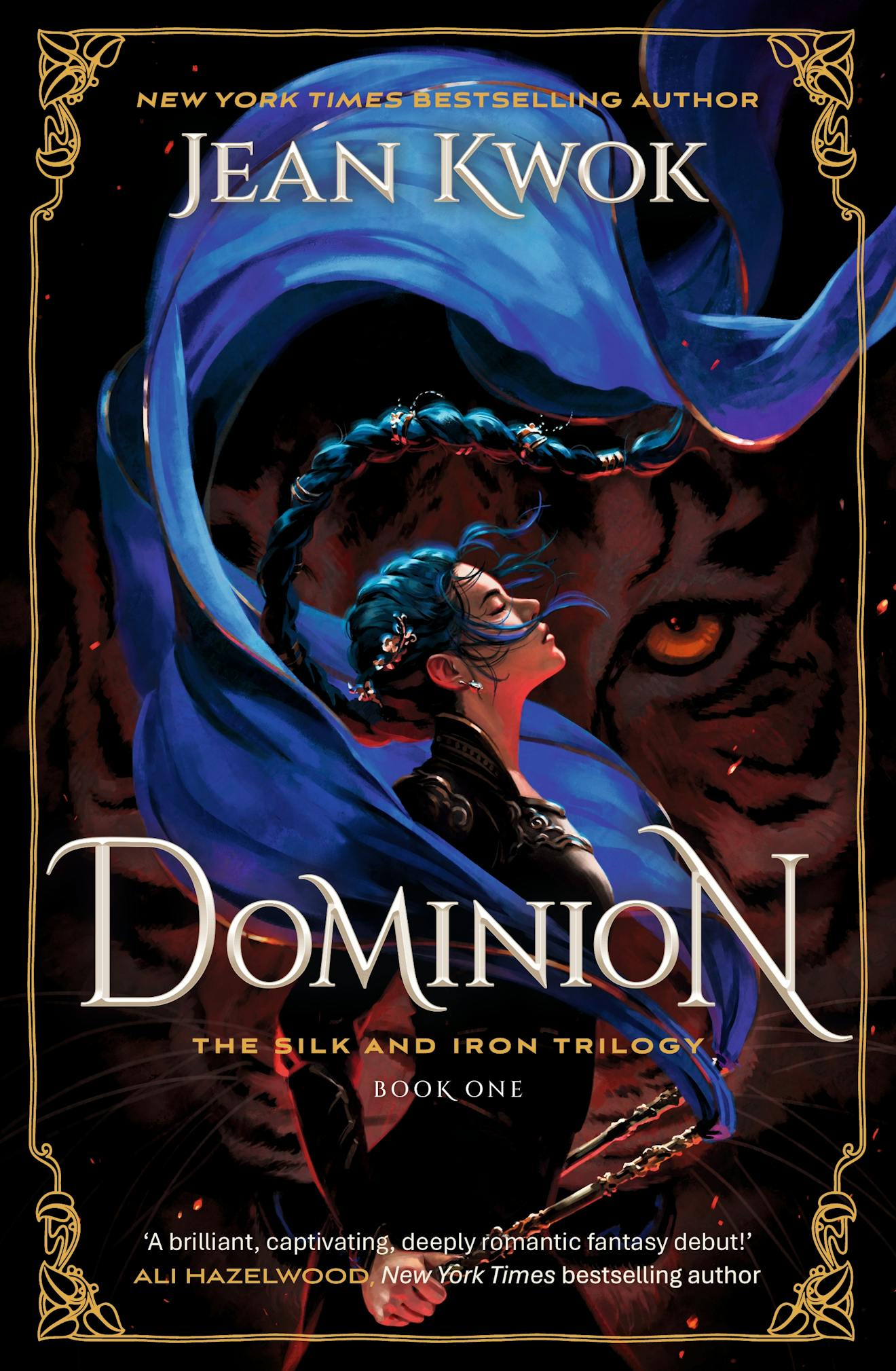 Book cover of 'Dominion' featuring a woman with blue hair and a flowing blue cloak against a dark background with a large orange-eyed tiger
