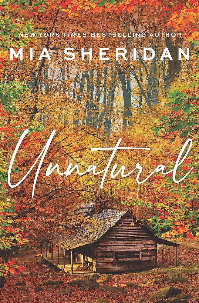 Book cover of 'Unnatural' by Mia Sheridan with a cabin and autumn foliage.