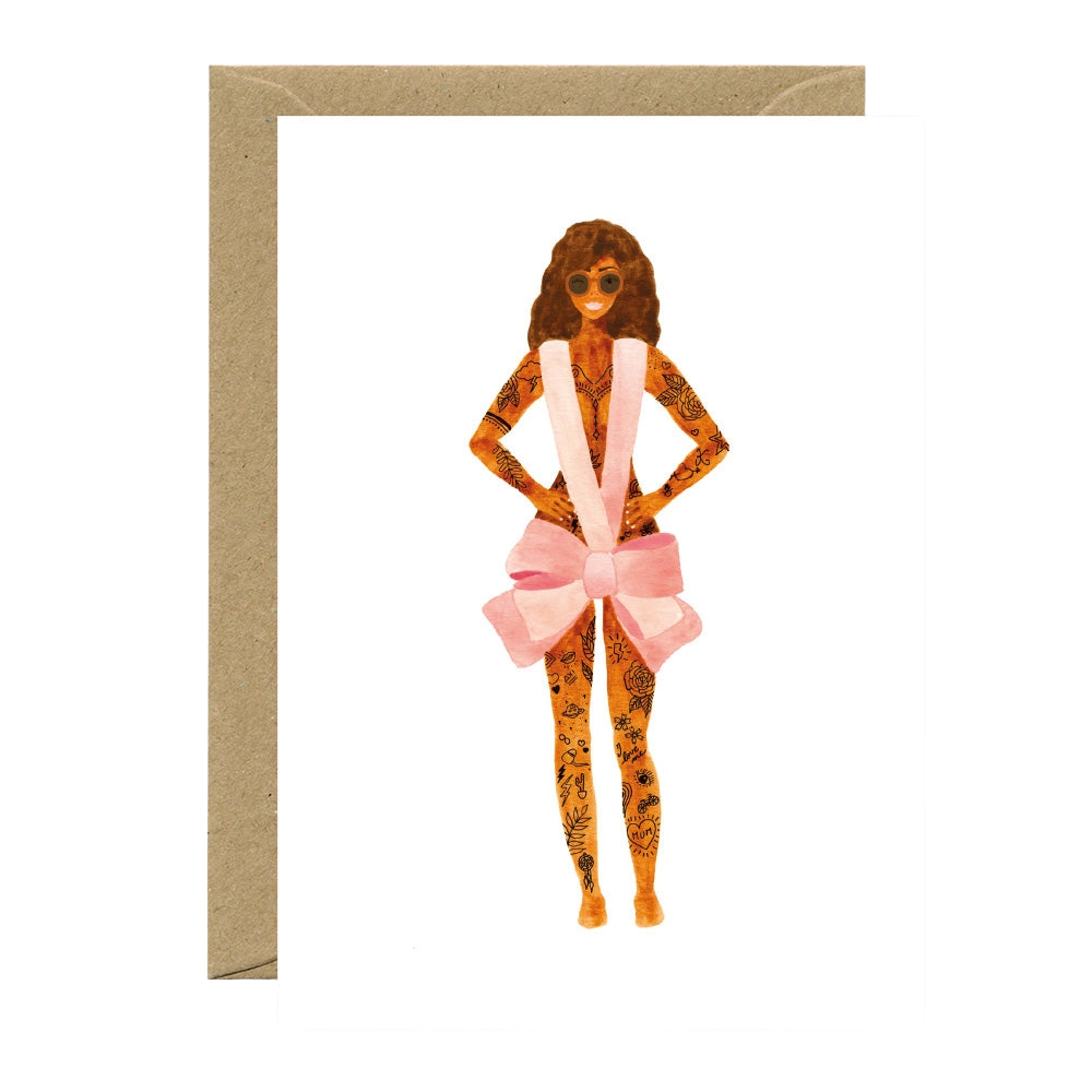 A tattooed woman dressed with a pink bow and sunglasses on a white background